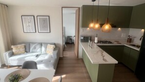 Um apartamento moderno com sala de estar, área de jantar e cozinha.