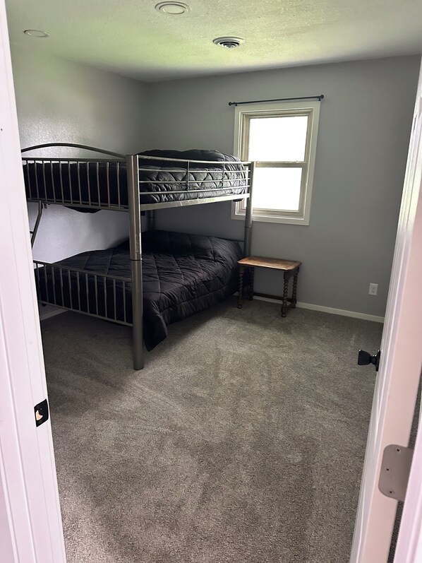 A room with a bunk bed, a small wooden table, and a window. - Spacious 4-bedroom house in beautiful Box Elder with AC (Box Elder)