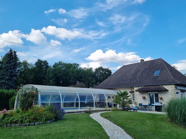 A house with a greenhouse, a stone pathway, and a lawn. - Chambre d'Hôte 'Chez Maddie' avec Piscine Couverte / B&B with heated pool (Aclou)