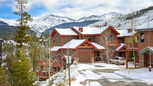 A lodge with a snow-covered landscape, wooden cabins, and a mountain backdrop. - Cloudline Chalet 3 Bedroom Townhouse (Winter Park)