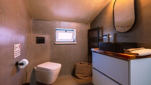 Un baño pequeño con inodoro, una ventana, un espejo y un lavabo con toalla.
