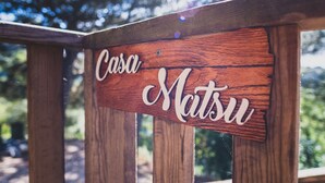 A wooden sign with the name "Casa Matsu" on a wooden railing.