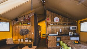 A cozy, wooden interior with a dining area, kitchen, and a sleeping area.