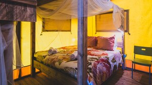 A four-poster bed with a canopy, a wooden floor, and a yellow wall.