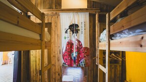 Una habitación tradicional japonesa con suelo de tatami, vigas de madera y un shoji con una pintura colorida.