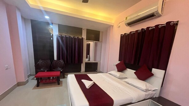 A modern hotel room with a bed, a small desk, a bench, and a sliding door leading to a bathroom. - Hotel Miracle Stay (Bhubaneshwar)