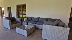 Un salon moderne avec un canapé d’angle, deux fauteuils et une table basse.