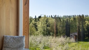 A room with a wooden wall, a window, and a view of a forest with a bridge. - Time Out in Argental – Holiday Home Hagg near Lake Constance (Neukirch)