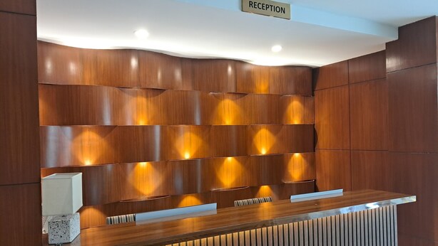 Un mostrador de recepción con detalles de madera y un cartel que dice 'RECEPTION'.