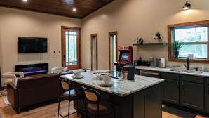 A spacious kitchen with a central island, wooden flooring, and a high ceiling with exposed beams. - Seduction Awaits – Bold, Romantic Escape for Adventurous Couples (Sevierville)