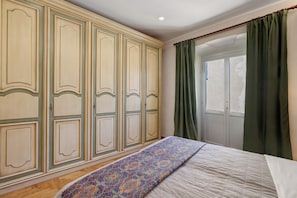 Une chambre à coucher avec un lit, une armoire et une fenêtre avec des rideaux.
