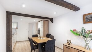 A dining area with a wooden table, black chairs, and a wooden cabinet with a vase of flowers. - Holiday Home 'Feußner' with Wi-Fi (Schwalmtal)