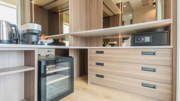 Een moderne keuken met een ingebouwde oven, een koffiezetapparaat en een magnetron.