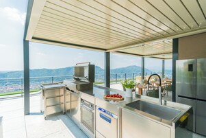 Una cocina moderna con vistas a montañas, una parrilla y un lavamanos.