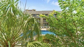 A hotel with a pool, surrounded by lush greenery. - Shipwatch Pointe II-K103 1BR Condo in Shore Dr (Myrtle Beach)