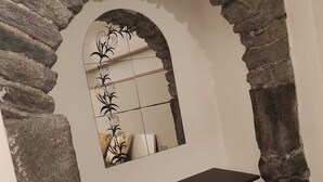 Une arche en pierre avec un miroir qui reflète une pièce.