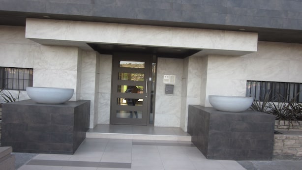 A modern building entrance with a large door, two large planters, and a date stamp. - Lovely condo with AC in vibrant Tijuana Excellent location main avenue SAFE (Tijuana)