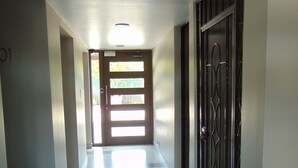 A hallway with a door at the end, a ceiling light, and a number '01' on the wall. - Lovely condo with AC in vibrant Tijuana Excellent location main avenue SAFE (Tijuana)