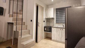 A modern interior with a staircase, kitchen, and seating area.