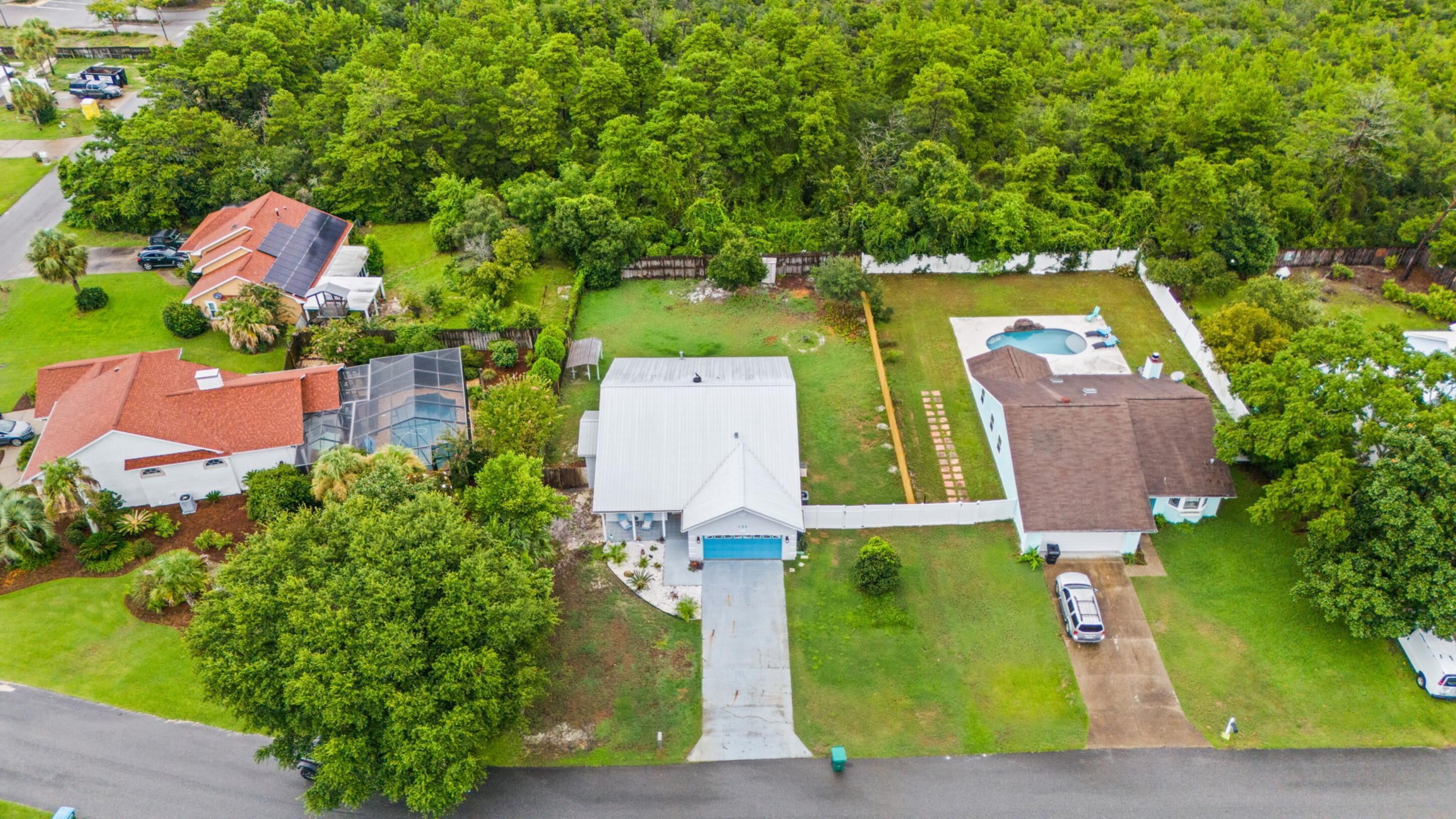 A residential area with multiple houses, a swimming pool, and a well-maintained lawn.