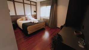 A modern hotel room with a large bed, wooden flooring, a bedside table with a lamp, and a large window with curtains. - Hotel Playa la Ñora by gaiarooms (Quintueles)