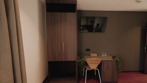 A modern kitchen with a built-in stove, a dining area with a chair and table, and a large cabinet with two doors. - Hotel Playa la Ñora by gaiarooms (Quintueles)