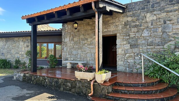 A stone building with a covered porch, a bench, and a staircase leading to the entrance. - Hotel Playa la Ñora by gaiarooms (Quintueles)