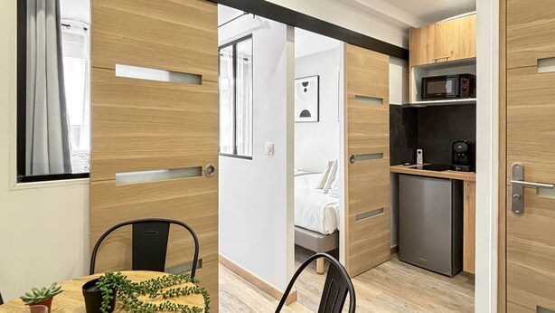 A modern kitchen with wooden cabinets, a microwave, and a refrigerator. - Hoche A 11 - Two Bedroom Apartment, Sleeps 5 (Paris)
