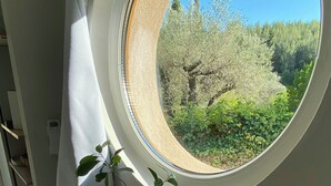 Una habitación con un ventanal redondo que da a un jardín.