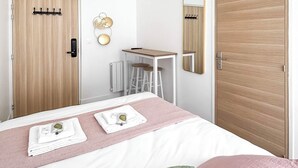 A modern bedroom with a bed, a desk, and a wardrobe. - Hoche C 105 - Studio Apartment, Sleeps 2 (Paris)