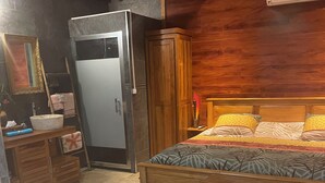 A compact bedroom with a bed, bedside table, and a wooden wardrobe. - Comfort bungalow (Saint-Paul)