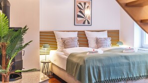 A modern bedroom with a bed, pillows, a wall-mounted artwork, and a small side table. - Residenz am Hostentor (Lübeck)