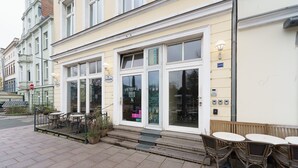 A cafe with outdoor seating, a visible entrance, and a signboard. - Residenz am Hostentor (Lübeck)