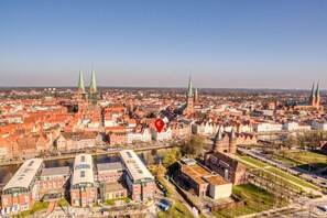 Vista aérea de una ciudad con edificios históricos, un río y una iglesia destacada con dos torres.