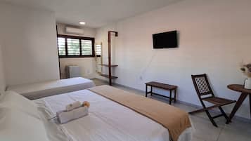 Habitación triple Deluxe, varias camas | Tabla de planchar con plancha, wifi gratis, ropa de cama