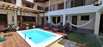 Una piscina al aire libre, sillones reclinables de piscina