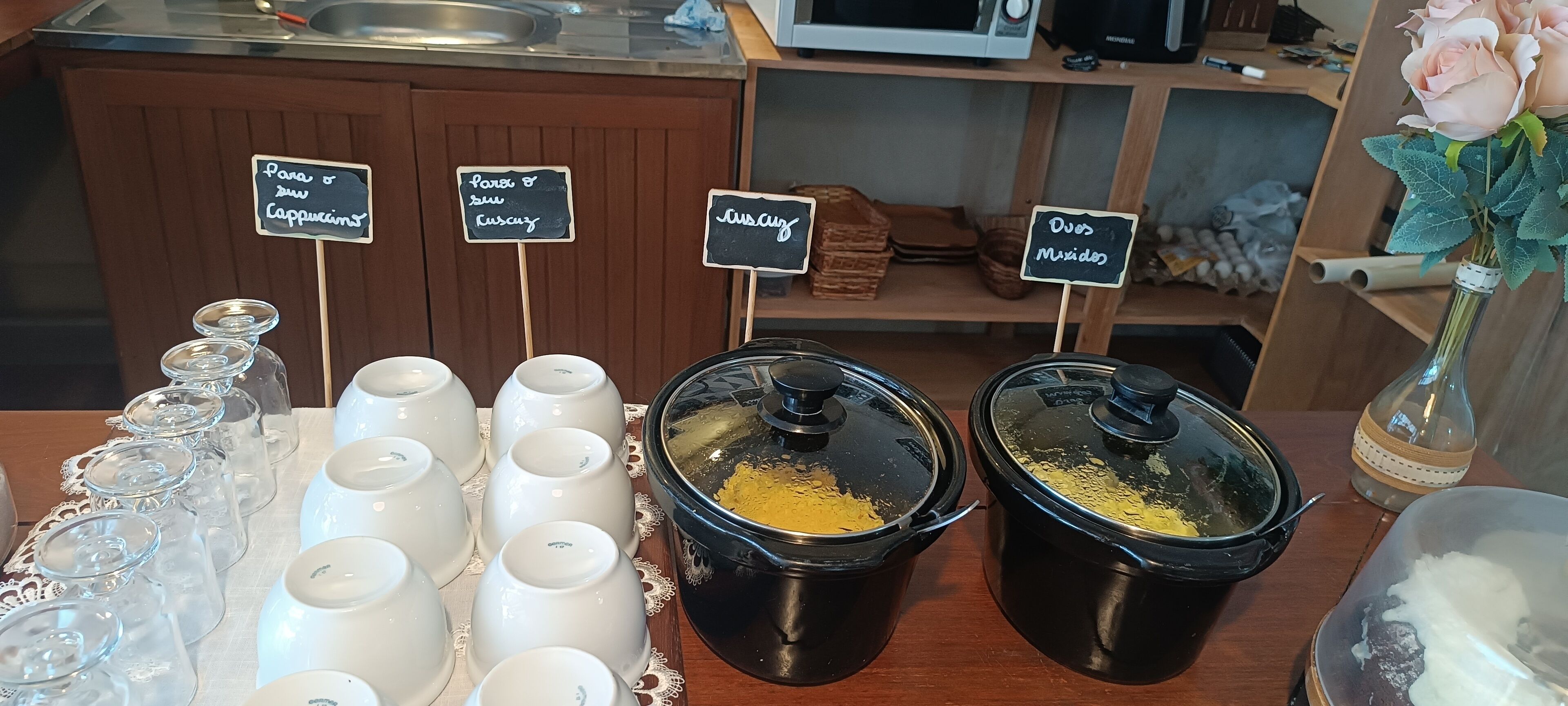 Una estación de café con recipientes etiquetados para distintos tipos de café y crema.