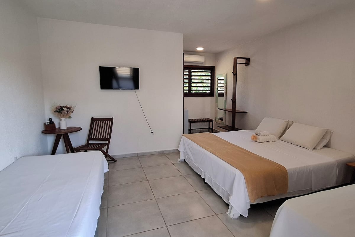 Habitación cuádruple Deluxe, varias camas | Tabla de planchar con plancha, wifi gratis, ropa de cama