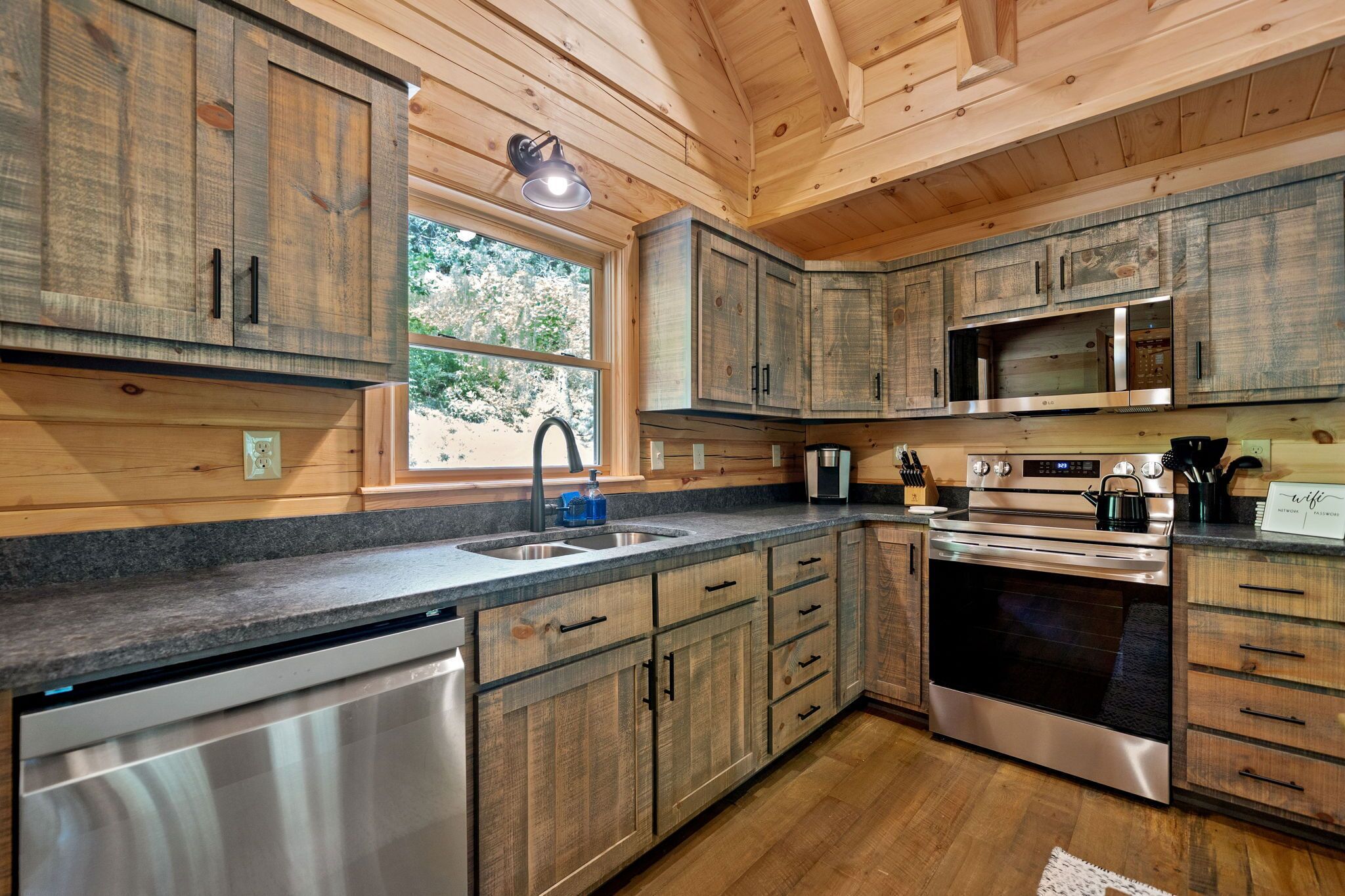 A modern kitchen with wooden cabinets, stainless steel appliances, and a built-in dishwasher.
