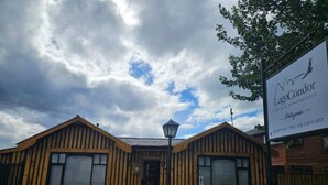 A wooden building with a signboard. - Hostal Lago Cóndor Patagonia (Puerto Natales)