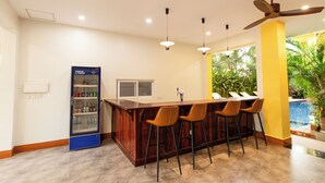 Una cocina moderna con barra, refrigerador y vista al exterior.