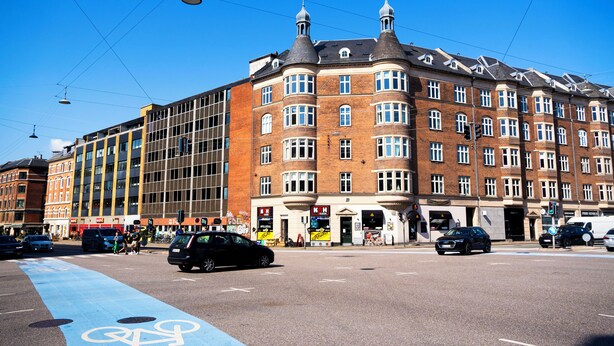 A multi-story building with a corner entrance, large windows, and a bike lane on the street. - Stylish Central 4-person CPH Apt. (København)