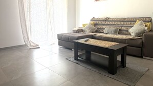 Una sala de estar con un sofá, una mesa de centro y un cuadro en la pared.