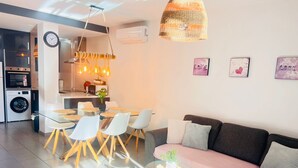 Un espacio habitable moderno con comedor, sofá y cocina.