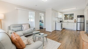 Ein modernes Apartment mit Wohnzimmer, Küche und Essbereich.