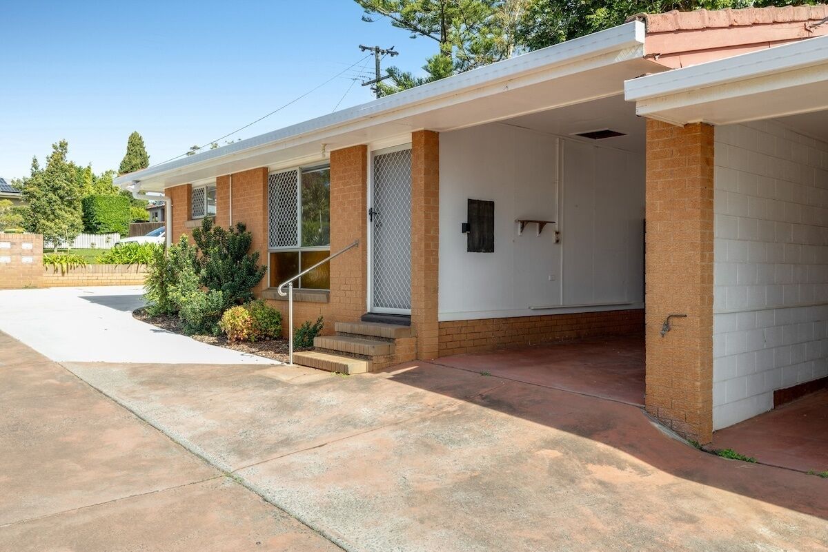 A single-story house with a covered porch, brick exterior, and a small front yard with landscaping.