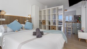Una habitación de hotel moderna con una cama grande, un escritorio y una kitchenette.