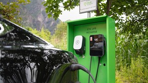 A green electric vehicle charging station with a car connected to it, surrounded by greenery. - Apartment 'Appartamento' with Mountain View, Wi-Fi and Air Conditioning (San Cassiano)