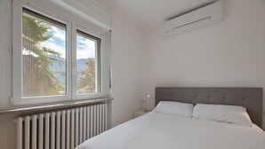 A bedroom with a bed, a window, a radiator, and an air conditioning unit. - Apartment 'Appartamento' with Mountain View, Wi-Fi and Air Conditioning (San Cassiano)