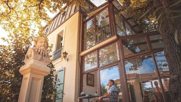 A building with large windows, a balcony, and a statue in the foreground. - Villa Kumquats (Béziers)